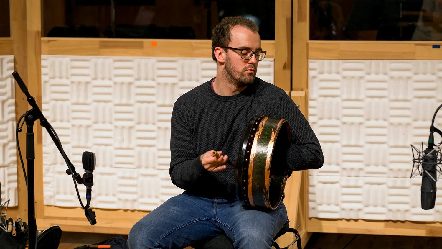 Percussionist playing a bodhrán with a wooden beater during a recording session at Vienna Synchron Stage